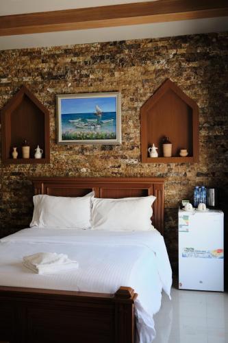 a bedroom with a bed and a brick wall at Durrat Nizwa Inn in Nizwa