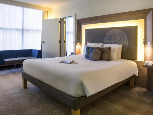 a large bed in a hotel room with a large bed at Novotel Genève Centre in Geneva