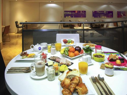 a white table with breakfast foods and drinks on it at Novotel Genève Centre in Geneva