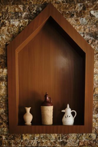 three vases sitting on a shelf in a wall at Durrat Nizwa Inn in Nizwa