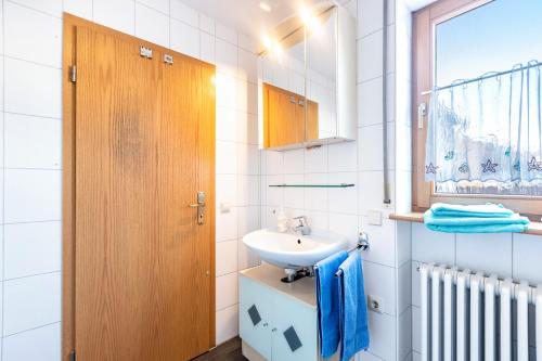 a white bathroom with a sink and a mirror at Ferienwohnung Hewenpanorama 1 in Engen