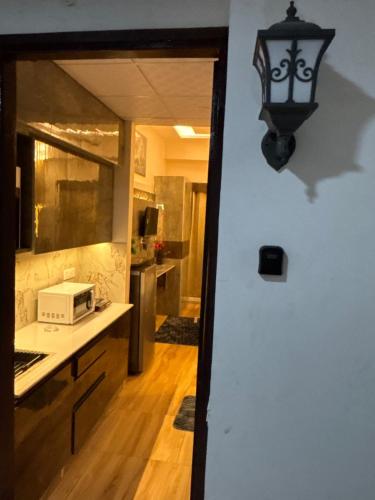 a kitchen with a microwave on a counter and a light at Anmolairbnb in Greater Noida