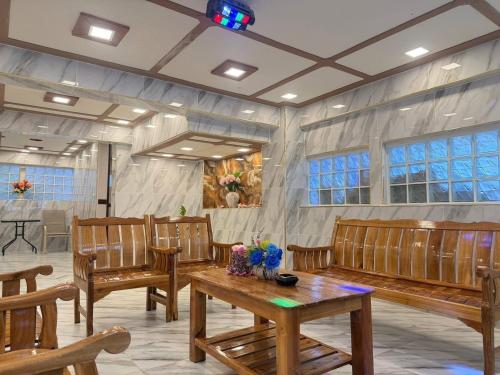 a waiting room with wooden benches and a table at Angel Pool Villa Phuket - SHA Extra Plus in Phuket Town
