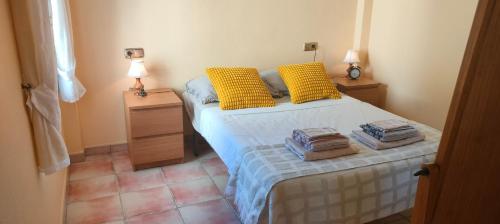 a bedroom with a bed with yellow pillows on it at Juweeltje van Hondon, met groot zwembad en rust in Hondón de las Nieves