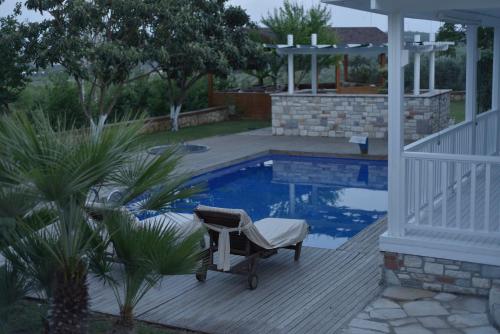 a chair sitting on a deck next to a swimming pool at Casa del Olivia in Seferihisar