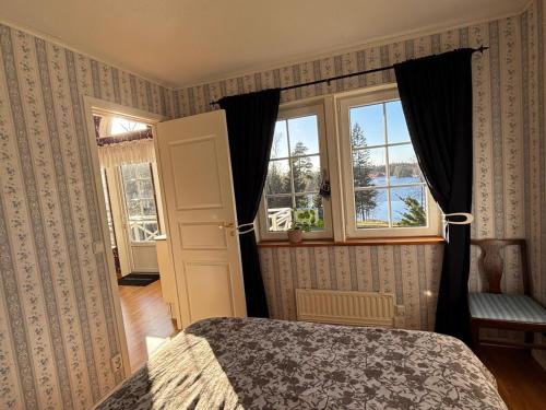 a bedroom with a bed and a window at Stunning lakeside home with sauna surrounded by nature in Sandared