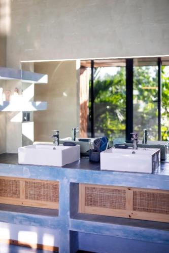 a bathroom counter with two sinks and a mirror at Sumba Lodge in Manuel Antonio