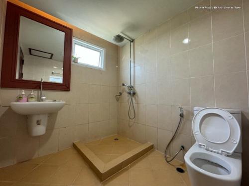 a bathroom with a toilet and a sink and a mirror at Angel Pool Villa Phuket - SHA Extra Plus in Phuket Town