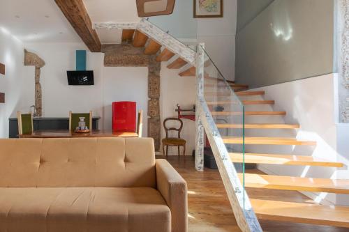 a living room with a couch and stairs at Memórias Charme Residences in Covilhã