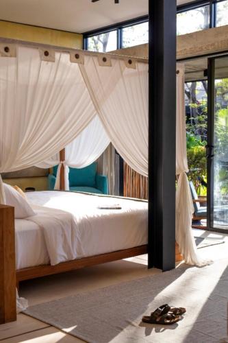 a bedroom with a bed with white drapes at Sumba Lodge in Manuel Antonio