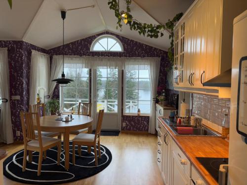 a kitchen with a table and chairs in a room at Stunning lakeside home with sauna surrounded by nature in Sandared