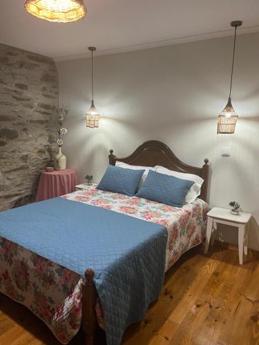 Un dormitorio con una cama con un edredón azul. en Casa Imperatriz, en Vilar de Ledra