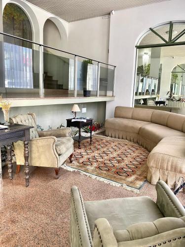a living room with couches and chairs and a table at Hotel Ponta Grossa São Marcos in Ponta Grossa