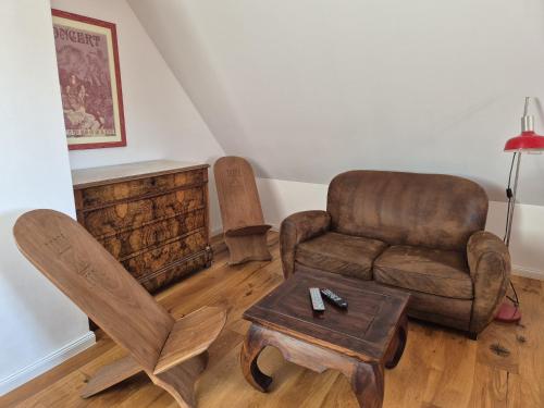 a living room with a couch and a chair and a table at An der KULTURSCHMIEDE in Kallmünz