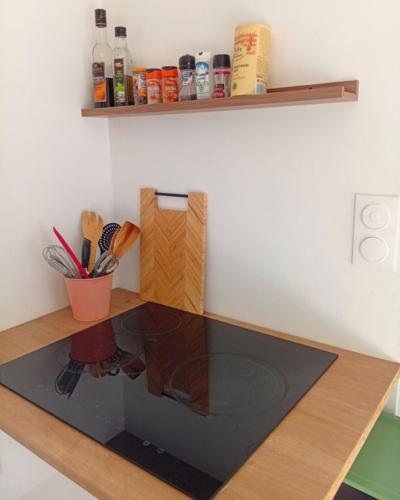 a kitchen counter with a glass table with utensils at L'Escapade in Villers-sur-le-Roule