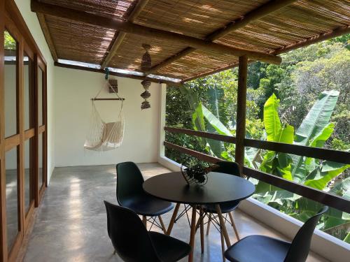 イタカレにあるRecanto da Luzのテーブルと椅子と大きな窓のある部屋