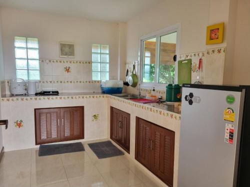 a kitchen with a refrigerator and a counter top at Wind in the Wild Khao Yai in Nakhon Ratchasima