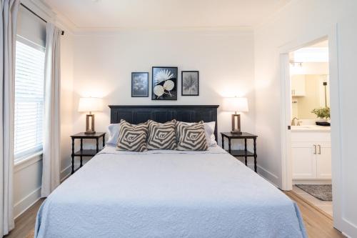 a white bedroom with a large bed and two lamps at The Blue Heron Haven in Baton Rouge