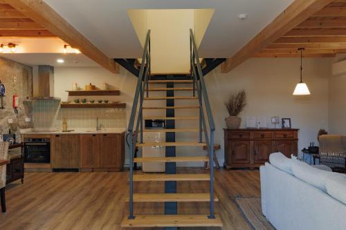a wooden staircase in a living room with a kitchen at Quinta de São Francisco Houses in Viseu