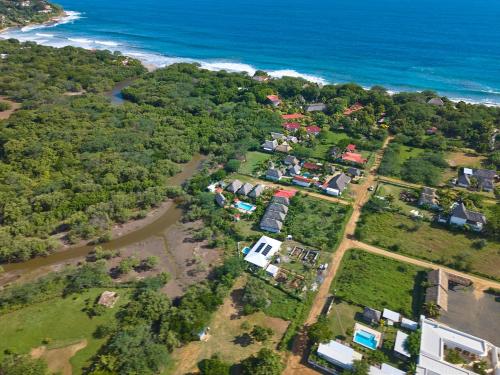 an aerial view of a group of houses next to the ocean at Banana Tree Popoyo in Popoyo