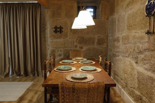 a dining room with a wooden table with plates on it at Quinta de São Francisco Houses in Viseu