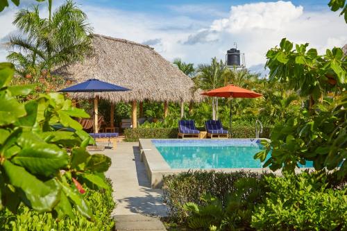 a resort with a swimming pool and umbrellas and chairs at Banana Tree Popoyo in Popoyo
