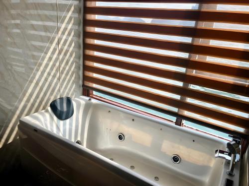 a bath tub in a bathroom with a window at Verdure Lotus Grandeur Cruise on Ha Long Bay in Ha Long