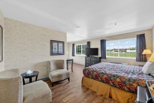 a hotel room with a bed and a chair at Colfax Inn By Marifah in Colfax