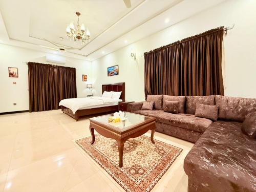 a living room with a couch and a bed at Comfort Family Lodges in Islamabad