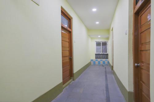 an empty hallway with two wooden doors and a window at SPOT ON SR CONTINENTAL in Hyderabad