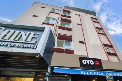 a tall white building with a blue tri hotel and suites at SPOT ON SR CONTINENTAL in Hyderabad
