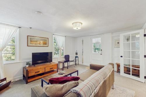 a living room with a couch and a flat screen tv at Multnomah Village Hideaway in Portland