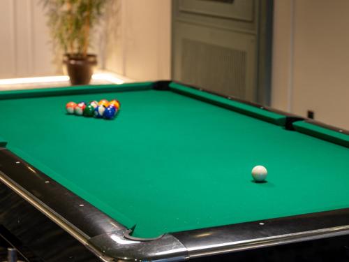 a green pool table with a cue ball on it at Shirvan Grand Hotel Shamakhi in Şamaxı