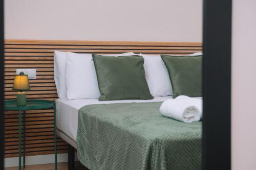 a bedroom with a bed with green and white pillows at Calidez y encanto en Vigo centro by CABANA Rentals in Vigo