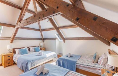 Zimmer im Dachgeschoss mit 2 Betten und einer Treppe in der Unterkunft Puffin Cottage, Bamburgh in Bamburgh