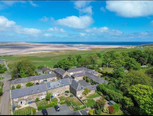 an aerial view of a house with the ocean in the background at Puffin Cottage, Bamburgh in Bamburgh