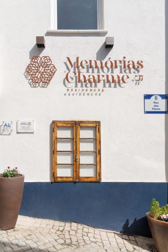 a sign on the side of a building with a window at Memórias Charme Residences in Covilhã