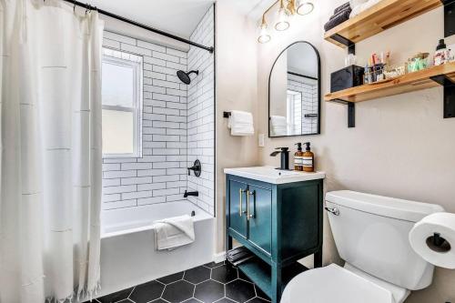 a bathroom with a toilet and a sink and a tub at Across The Street From Von Stiehl-newly Renovated! in Algoma