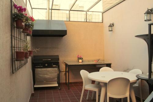 y cocina con mesa, sillas y fogones. en Hagoth Hostel en Buenos Aires