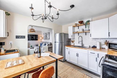 a kitchen with white cabinets and a wooden table at Across The Street From Von Stiehl-newly Renovated! in Algoma