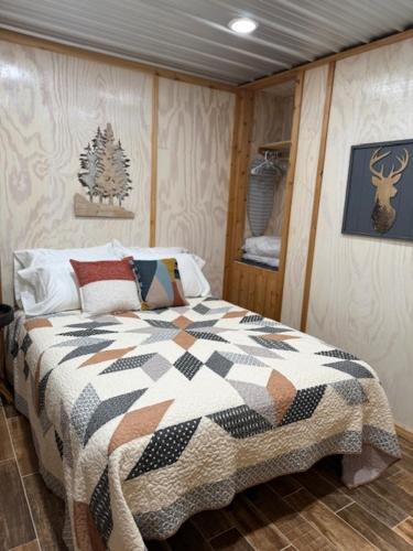 a bedroom with a bed with a quilt on it at Trails , Tails , and Scales Cabin 2 in Burkeville