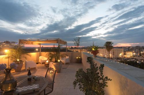 een balkon met een tafel en stoelen op een dak bij THE PLACE Ortigia in Siracusa