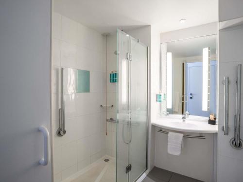 a bathroom with a glass shower and a sink at Novotel Glasgow Centre in Glasgow