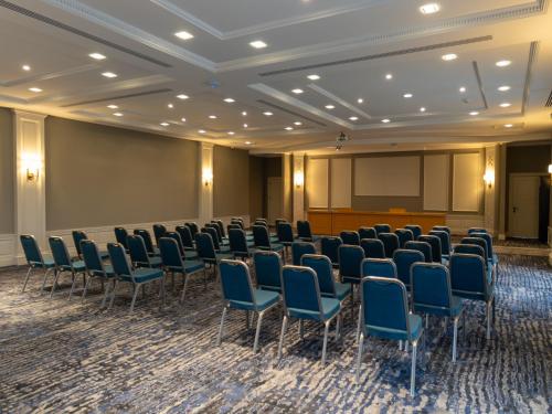 a conference room with chairs and a projection screen at Shirvan Grand Hotel Shamakhi in Şamaxı
