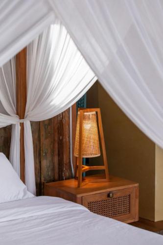 a bed with a table with a lamp on a night stand at Sumba Lodge in Manuel Antonio