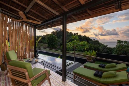 a room with a balcony with a view of the ocean at Sumba Lodge in Manuel Antonio