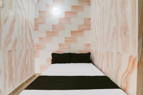 a bed in a room with a wall at Hotel O BRS Dream in Hasanganj