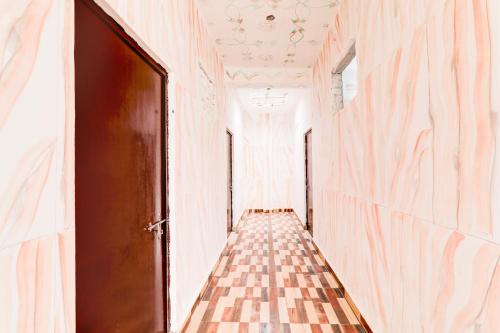 an empty hallway with a door and a checkerboard floor at Hotel O BRS Dream in Hasanganj