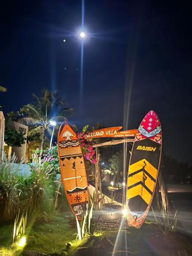 two surfboards on display in front of a building at night at Barland Villa in Ke Ga