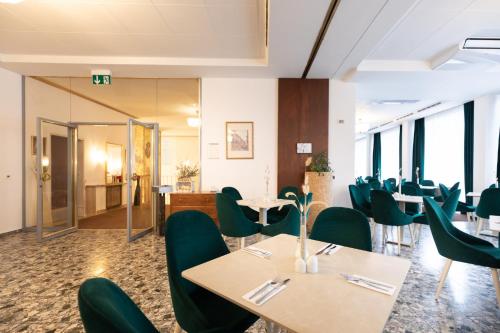 a dining room with tables and green chairs at Garner Hotel Vienna - Prinz Eugen by IHG in Vienna